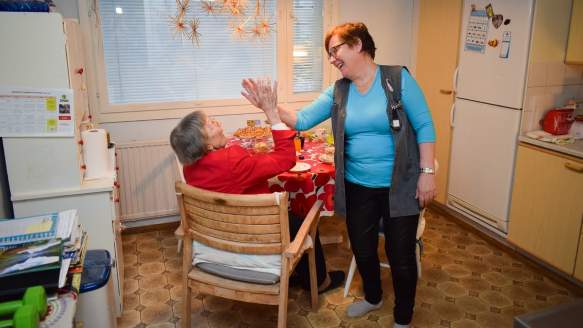 Auli Peltonen ja lähihoitaja Birgit Latva lyövät ylävitosen keittiössä.