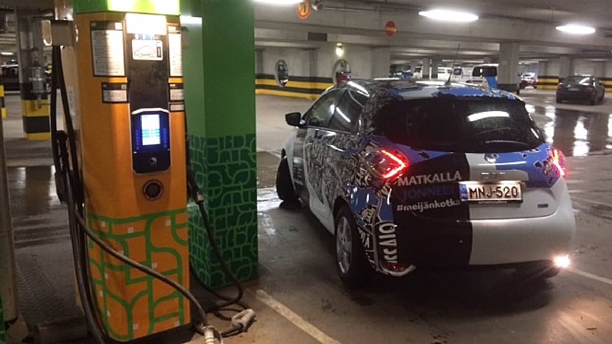 sähköauto lähtee liikkeelle latauspisteeltä parkkihallissa, Kotkan Toriparkki