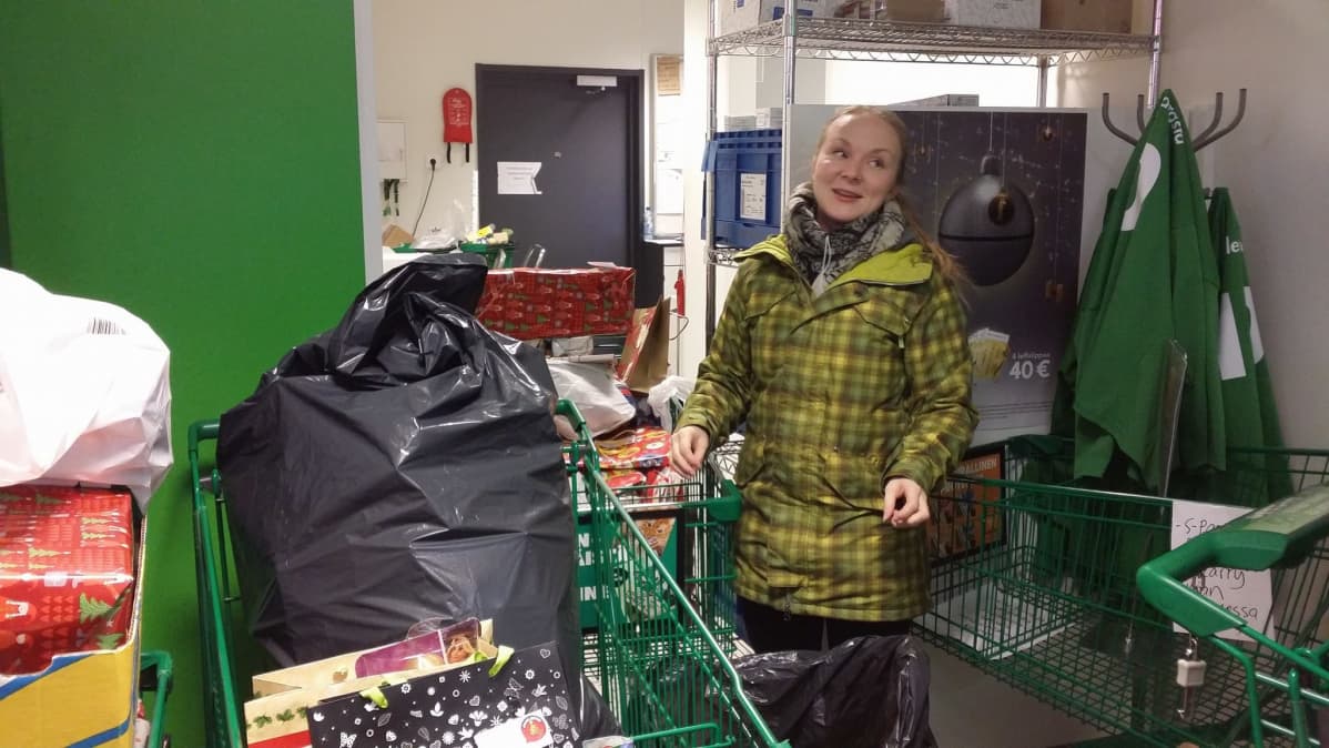 Jyväskylän Joulupuu-keräyksestä vastaava Annika Karjalainen lahjoituksia täynnä olevien ostoskärryjen keskellä.