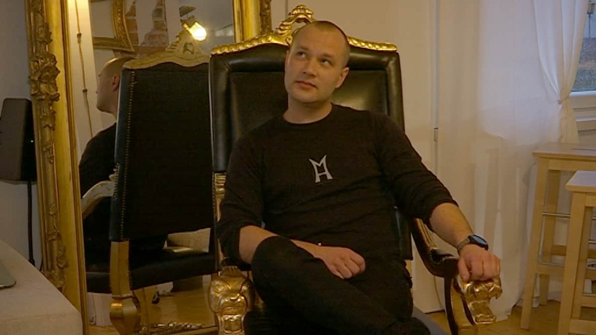 Mikael Holma istuu kullatulla nahkatuolilla.