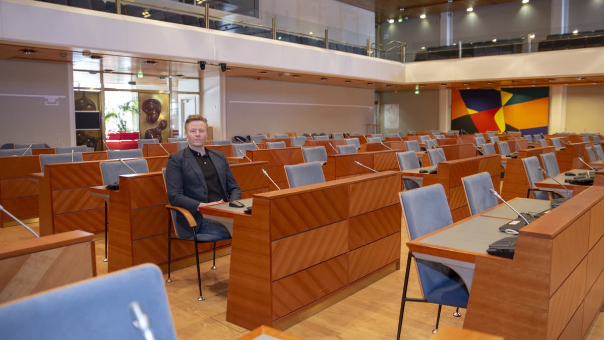 Mikki Kauste omalla työpisteellään Espoon valtuustosalissa.