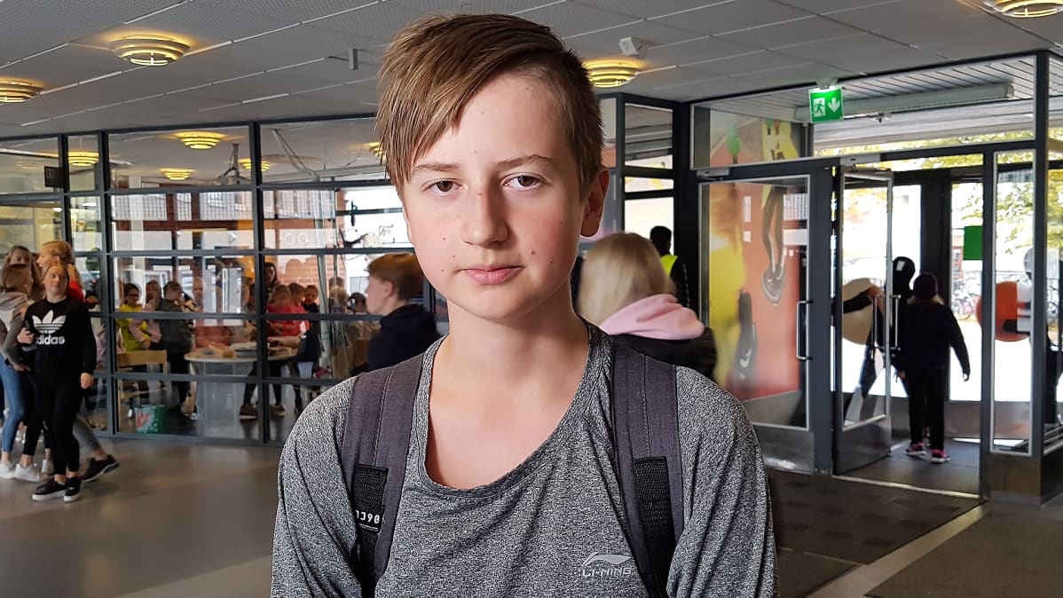 Roni Mäkiniemi seisoo koulun aulassa