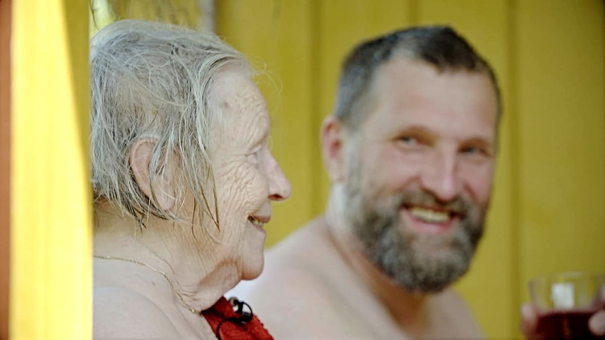 Anja Tuomela ja Pekka Tuomela vilvoittelevat kuistilla saunan jälkeen.