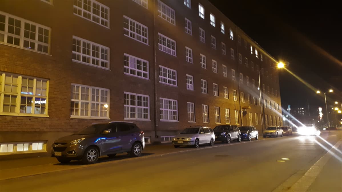 Autoja parkissa vanhan kerrostalon edessä