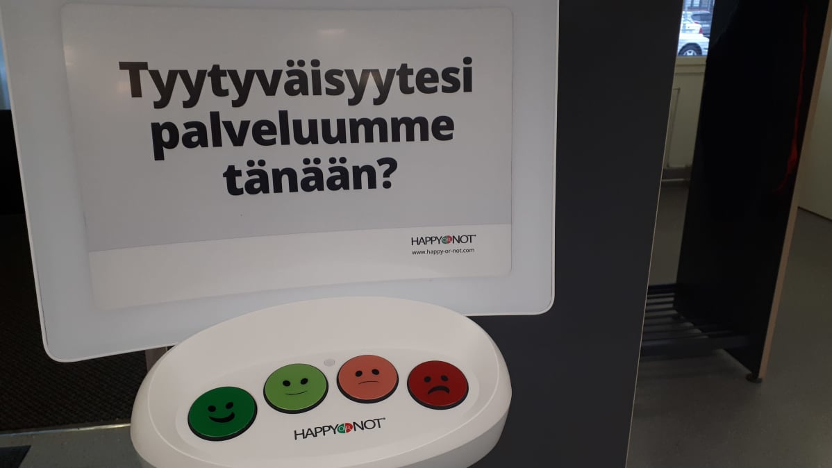 Tyytyväisyys palveluihin voidaan ilmaista hymynaamalla esimerkiksi terveyskeskuksen aulassa.