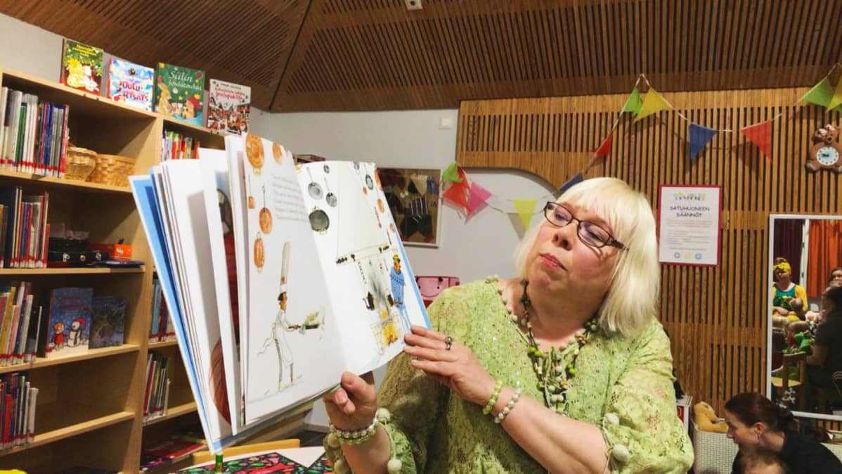 Kirjastonhoitaja lukee lastenkirjaa satutunnilla