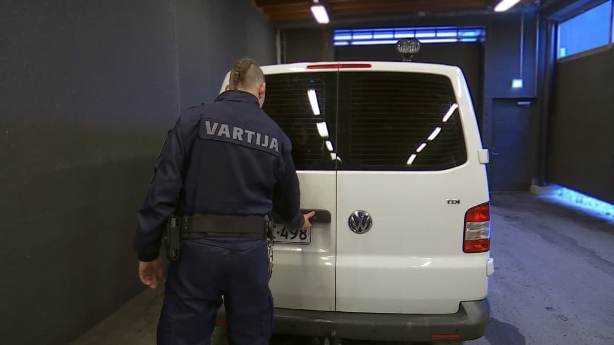 Vartija avaa kuljetusauton ovia