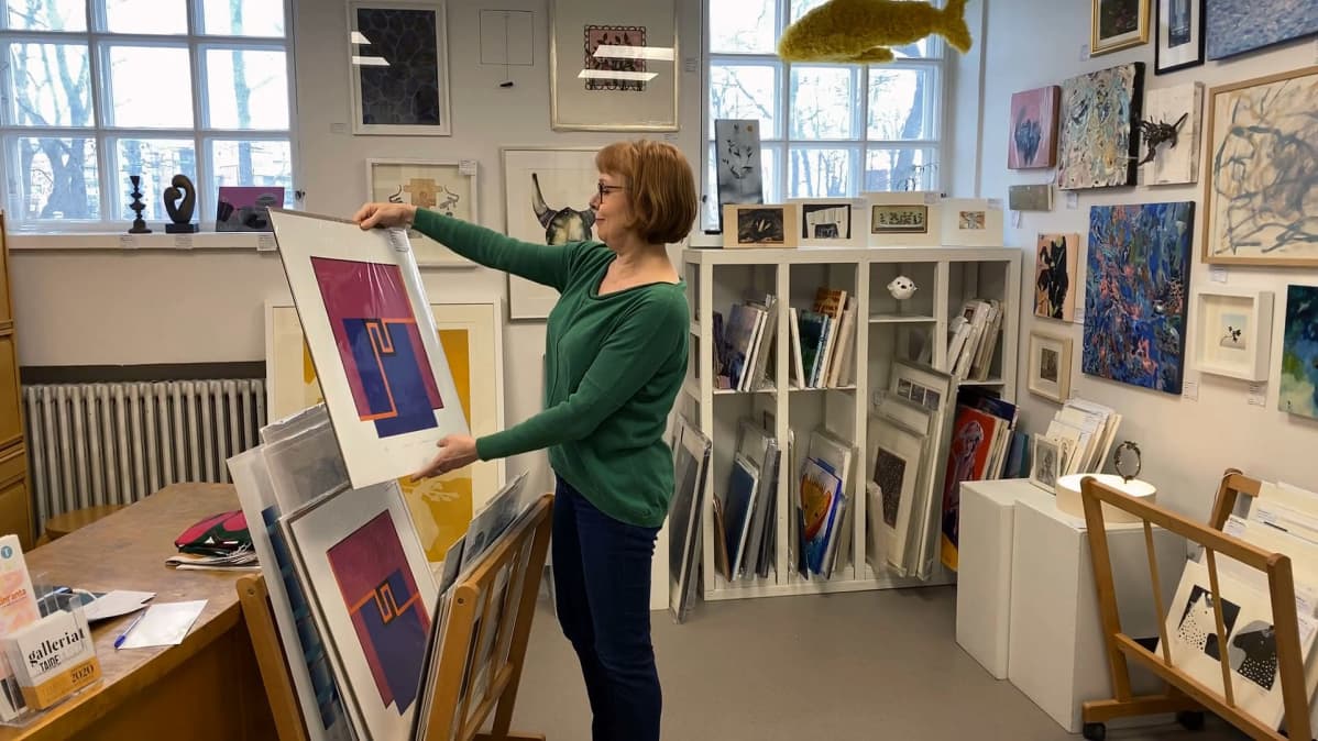 Anne Paldanius katselee taideteosta Tampereen taidelainaamossa