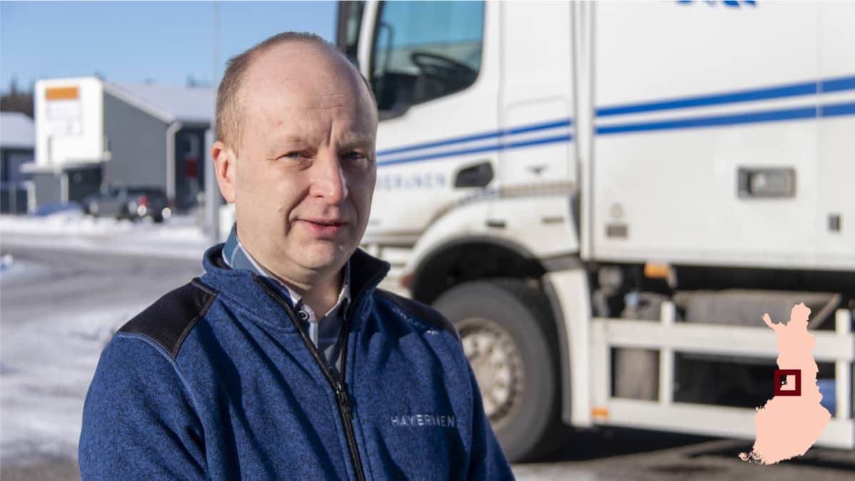 Janne Haverinen seisoo ulkona rekka taustalla