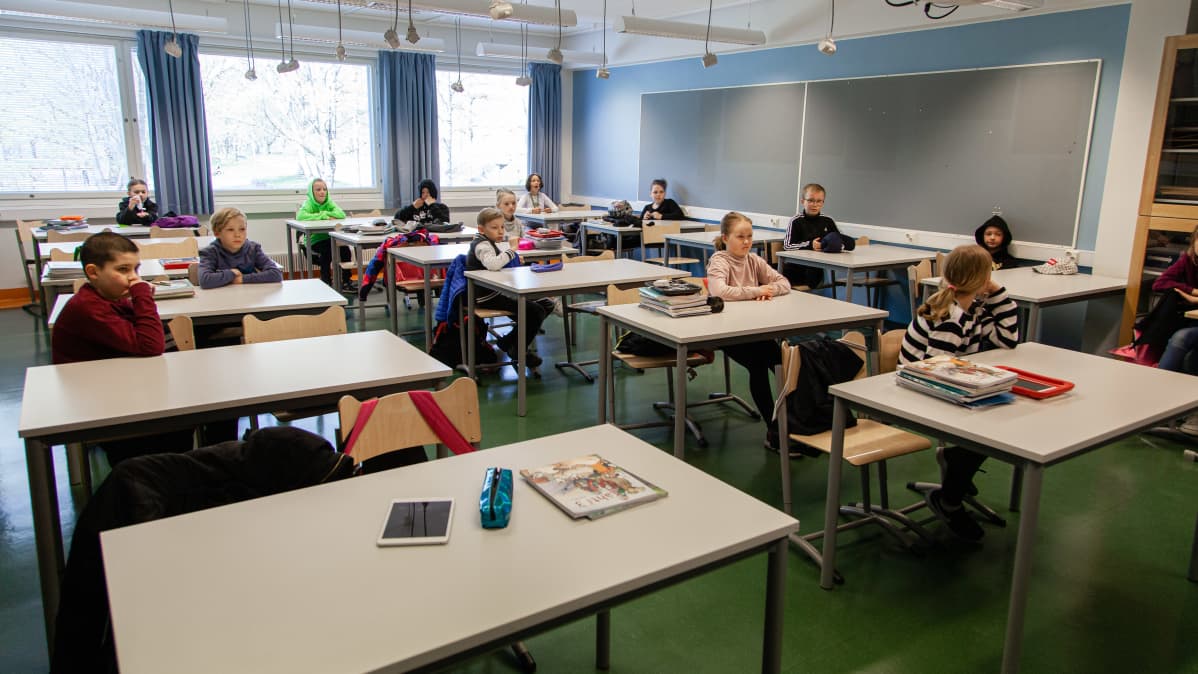 Oppilaat omissa pöydissä tunnilla.