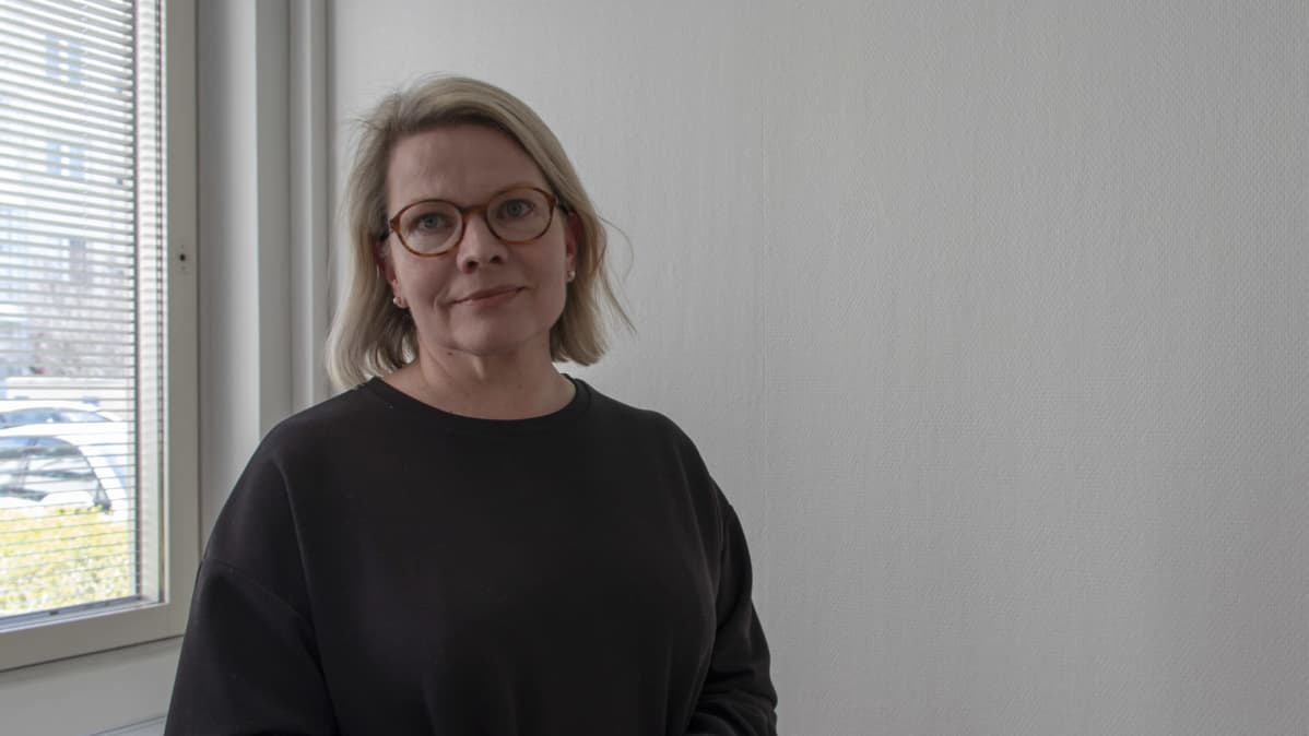 Anne Penttilä katsoo kameraan työhuoneessaan