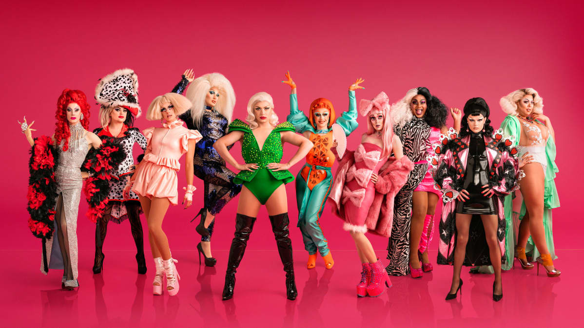 RuPaul's Drag Race UK -kilpailijat punaista taustaa vasten.