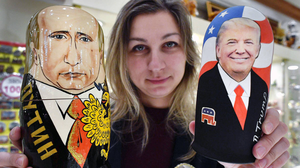 Myyjä esittelee Putinin ja Trumpin näköisiä puunukkeja lahjatavarakaupassa Moskovassa.