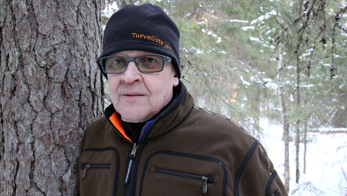 Kari Löppönen nojailee mäntyyn metsässä