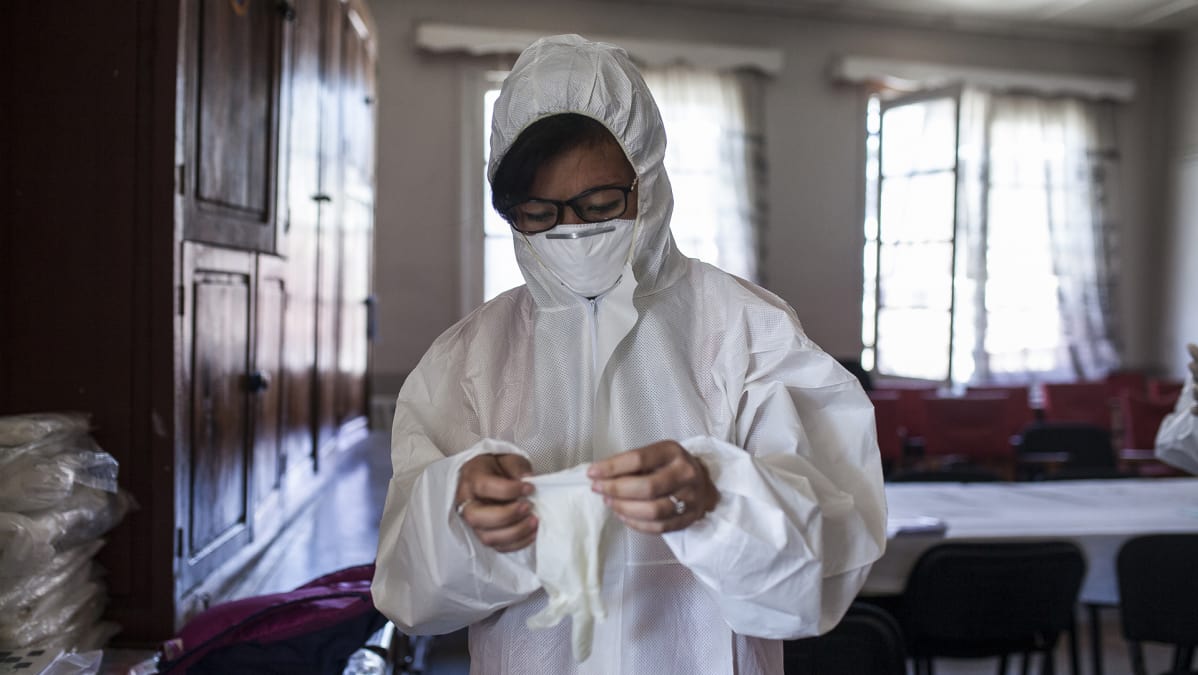 Rakotondravao, 25, madagaskarilainen Punaisen Ristin vapaaehtoinen valmistautuu ruttoon sairastuneen lapsen evakuointiin.