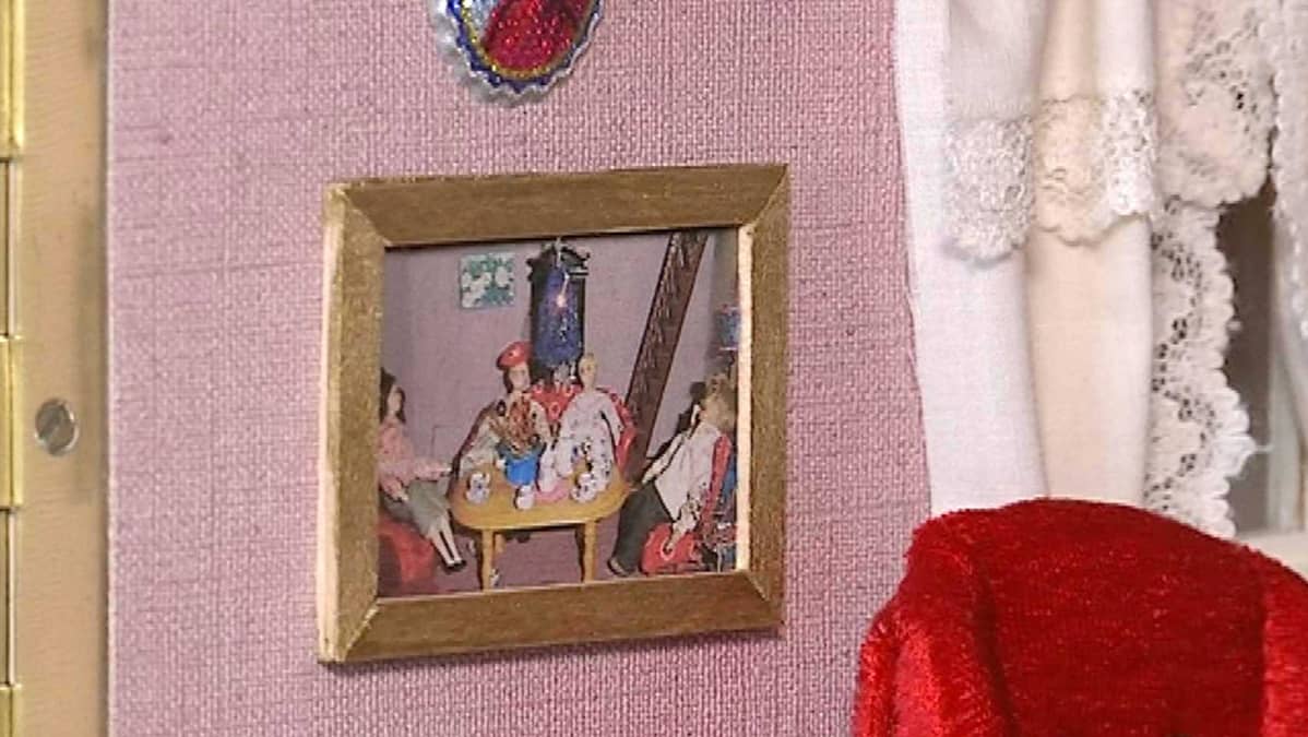 Miniatyyritaulu nukkekodin seinällä.