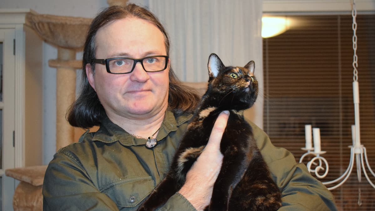 Villieläinhoitaja Jarmo Lautamäki kissa sylissään