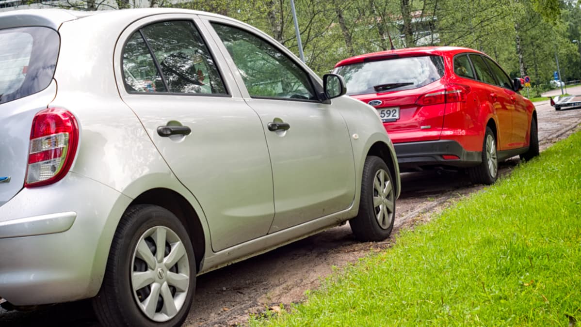 Hopeanharmaa ja punainen henkilöauto.