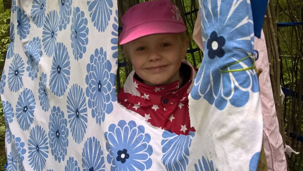 Sonja Korppi-Tommola kurkkaa majasta.
