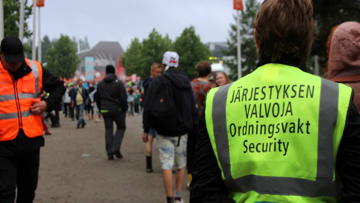 Järjestyksenvalvoja tarkkailee festivaaliväkeä Ilosaarirockissa.