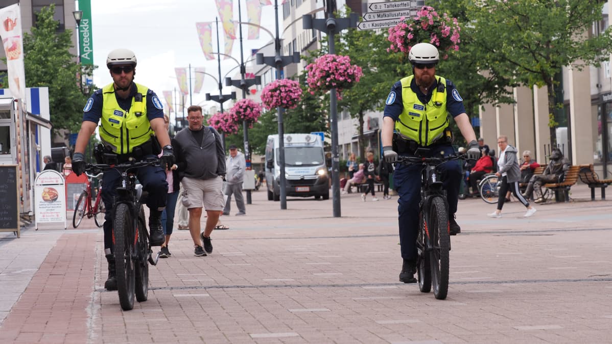 Polkupyörä poliisit ajavat kävelykadulla