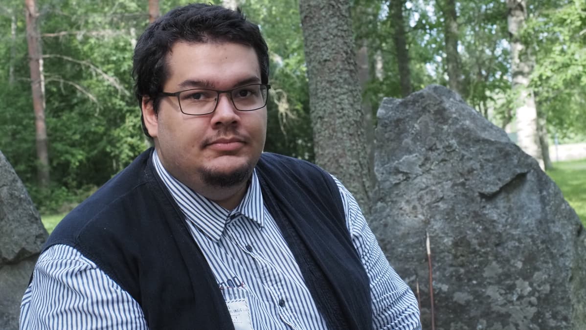 Mies istuu kivisen panssariesteen edessä