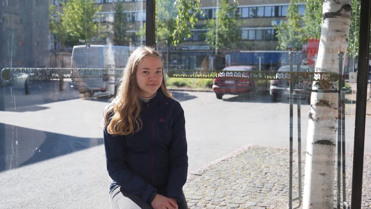 Joensuulainen Ekaterina Sallinen odottaa linja-autoa bussipysäkillä Joensuun keskustassa.