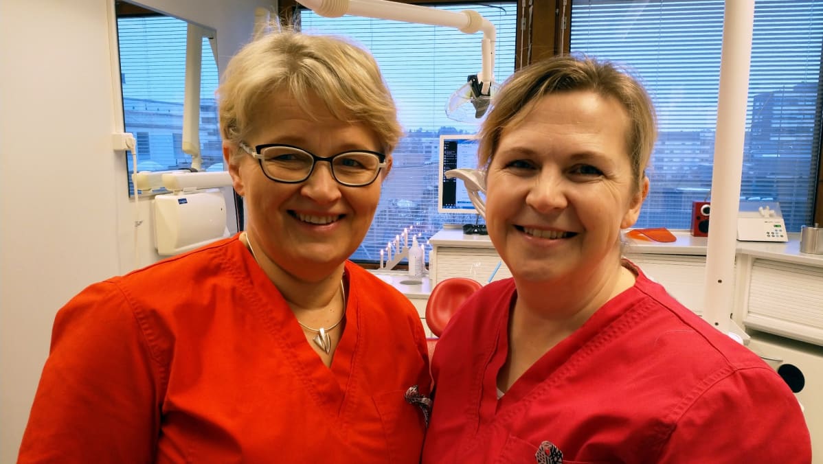 Kuvassa Kalevalapeittoa virkanneet hammaslääkärit Leena-Kaisa Hautakoski ja Jaana Uusisalo työpaikallaan.