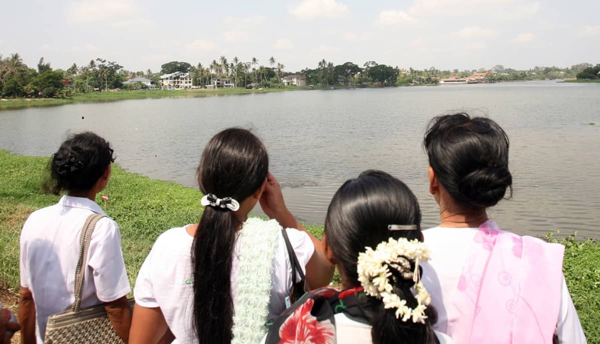 Aung San Suu Kyin kannattajia tämän kotitalon edustalla Yangonissa huhtikuussa 2010.