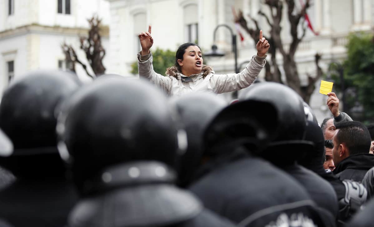 Mielenosoittajia ja mellakkapoliiseja Tunisissa.