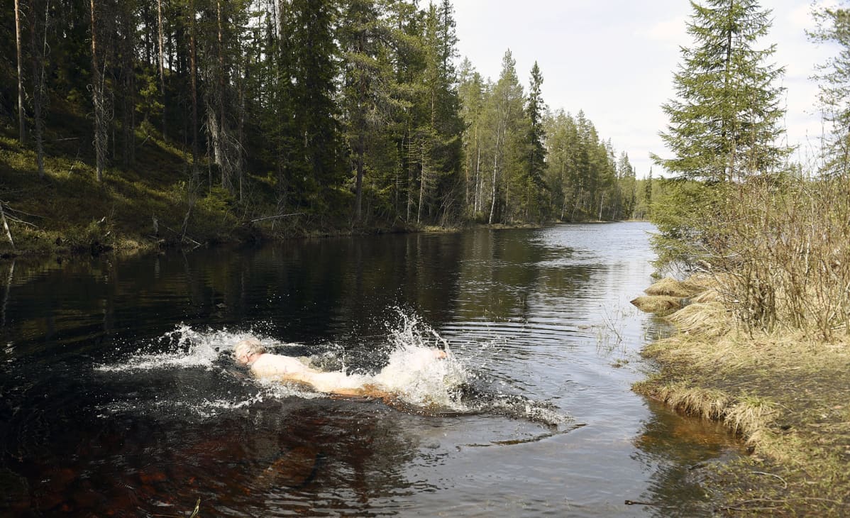 Mies ui korpijärvessä Hossan kansallispuistossa.