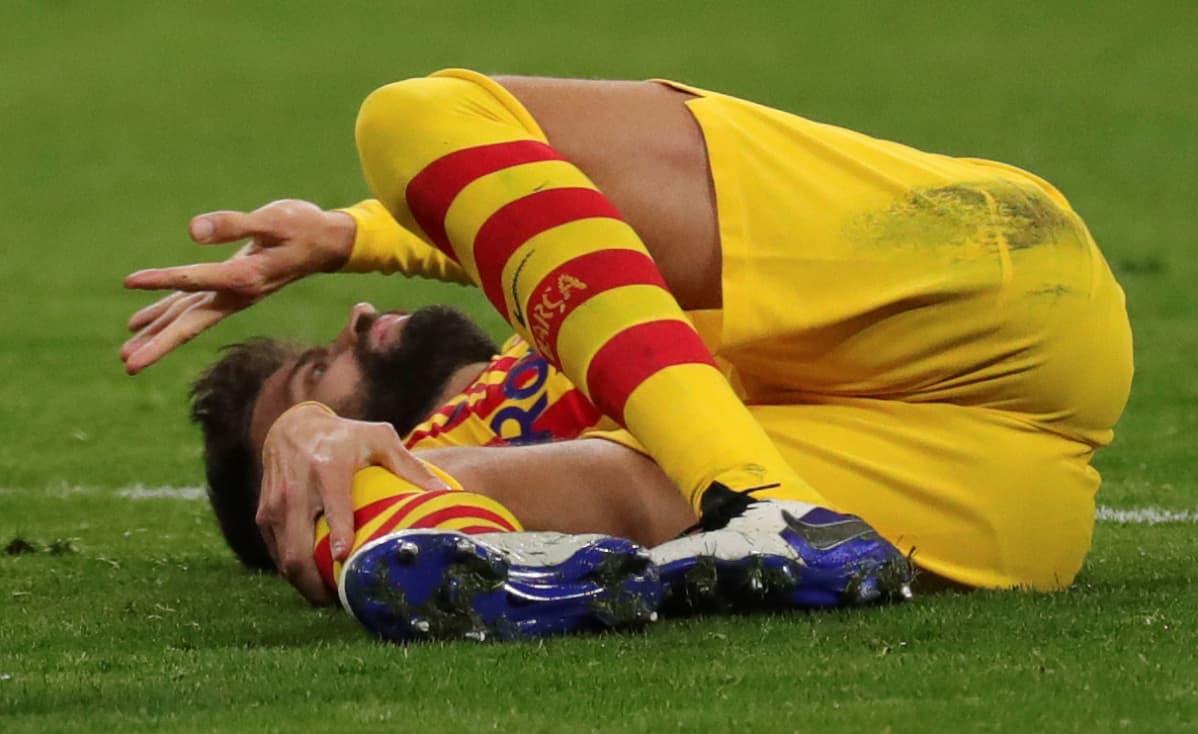 Gerard Pique makaa tuskaisena kentän pinnassa.