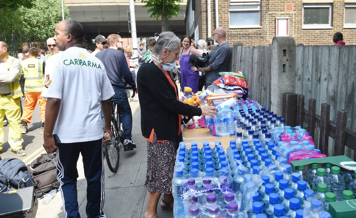 Ihmiset auttavat Grenfell Tower -kerrostalon asukkaita.
