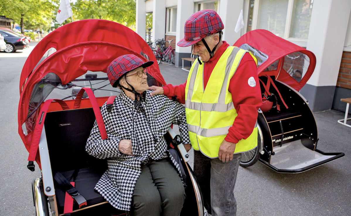 Matkustaja Sirkka Värtö ja riksan kuljettaja Mikko Lampinen ovat lähdössä matkaan.