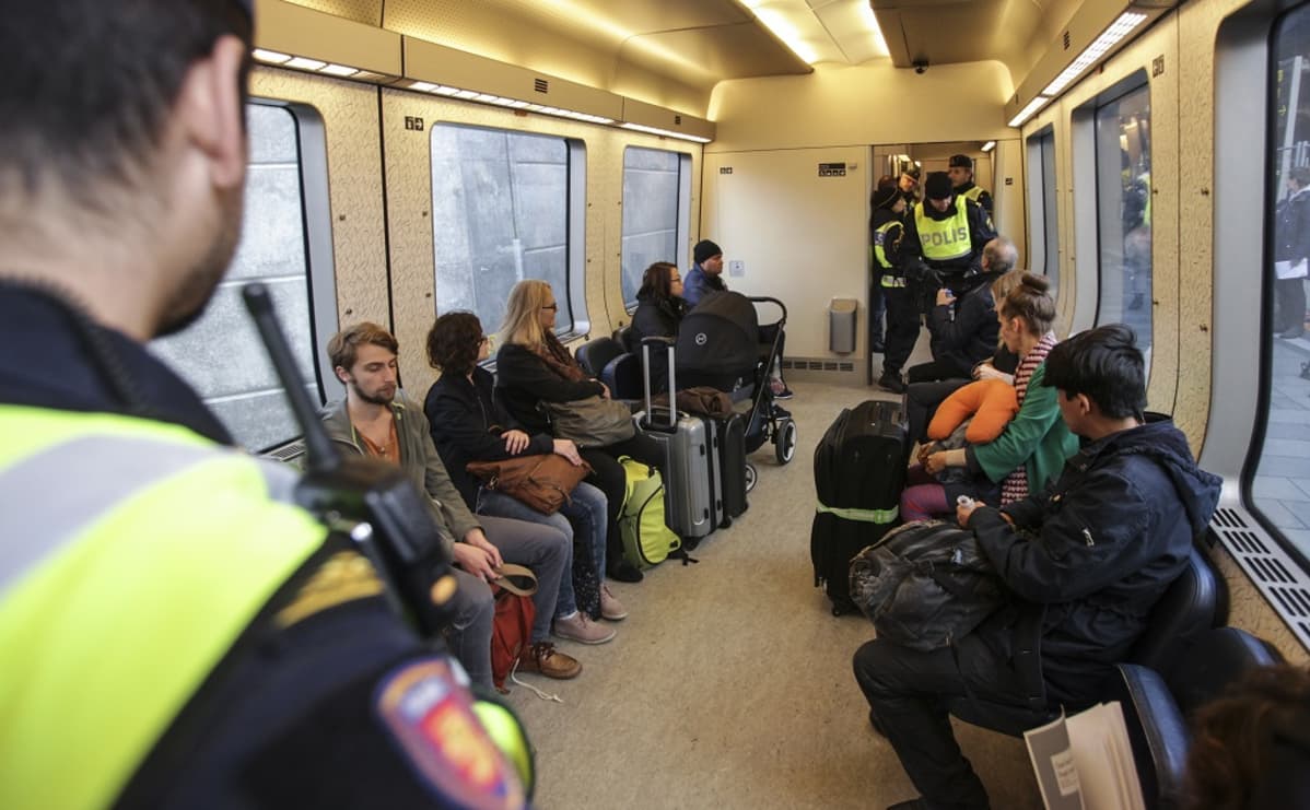 Poliisi tarkasti matkustajien henkilöllisyystodistuksia Tanskan ja Ruotsin välisessä junassa 12. marraskuuta 2015.