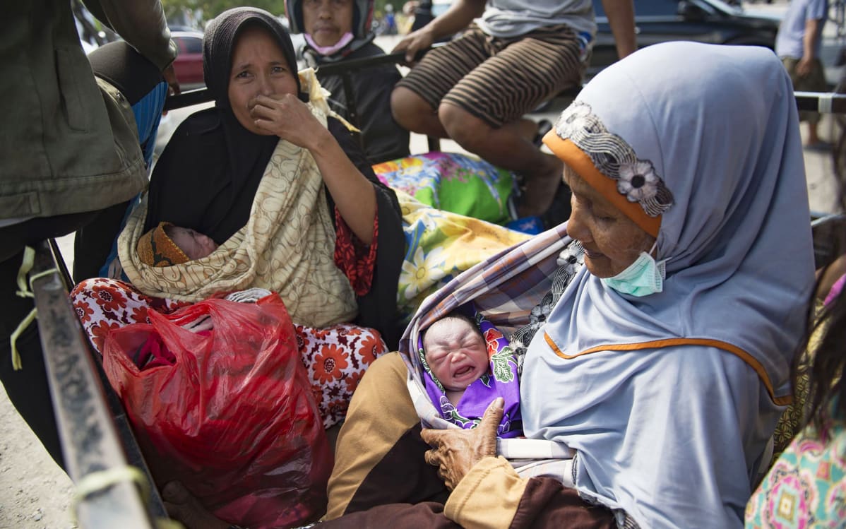 Nainen piti sylissään vastasyntynyttä lapsenlastaan Palussa, Indonesiassa 2. lokakuuta.