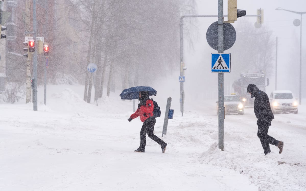 Ihmisiä lumimyräkässä.