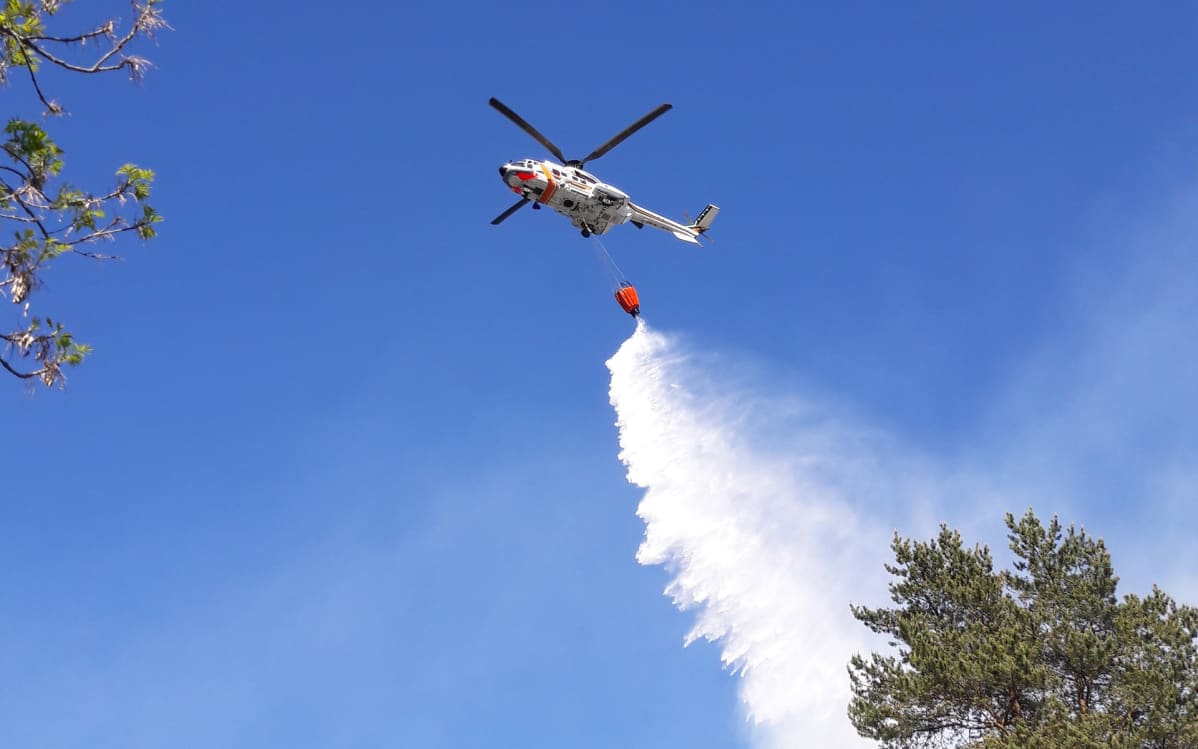 helikopteri taivaalla sammuttamassa metsäpaloa