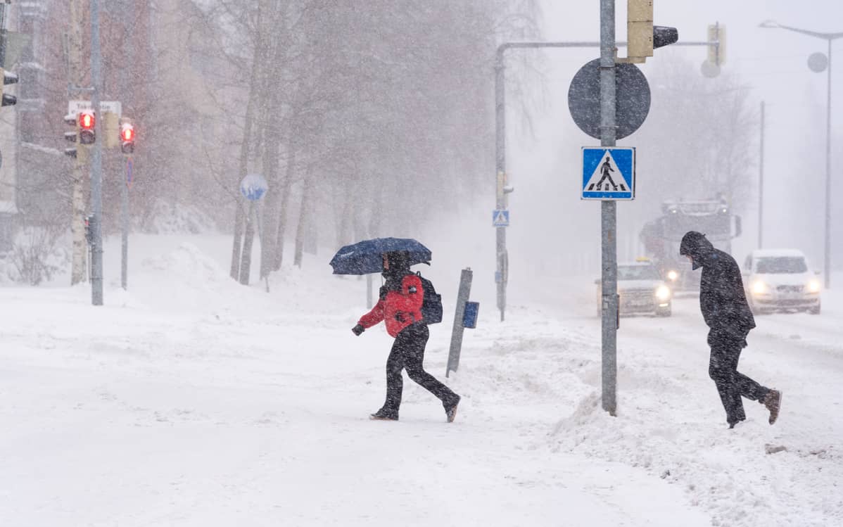 Ihmisiä lumimyräkässä.
