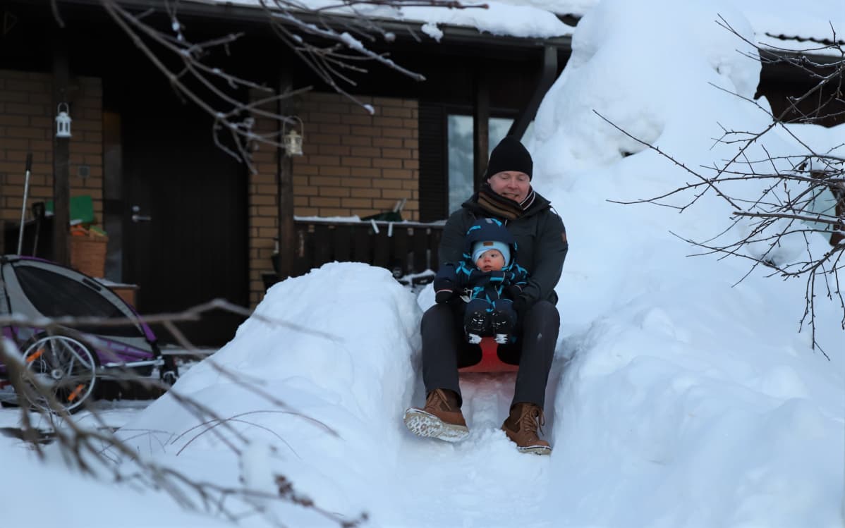 Isä laskee mäkeä poikansa kanssa
