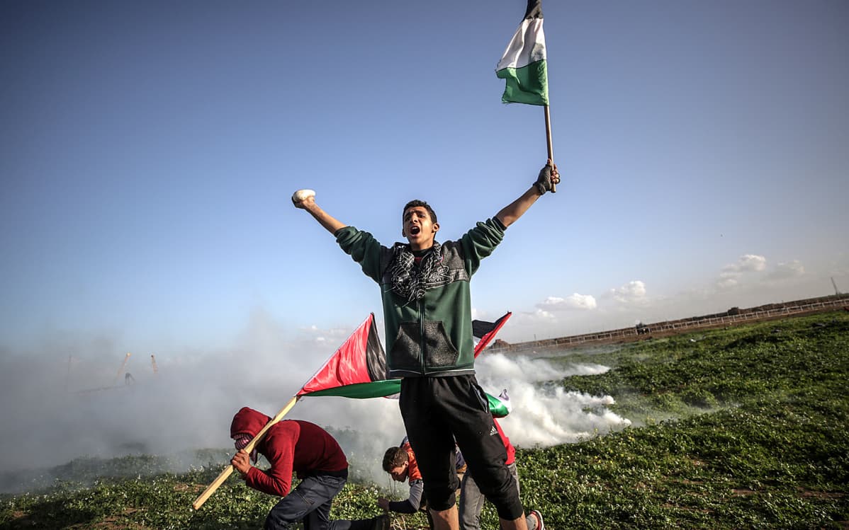 Palestiinalaiset mielenosoittajat suojautuivat Israelin armeijan kyynelkaasulta perjantain yhteenotoissa itäisessä Gazassa.