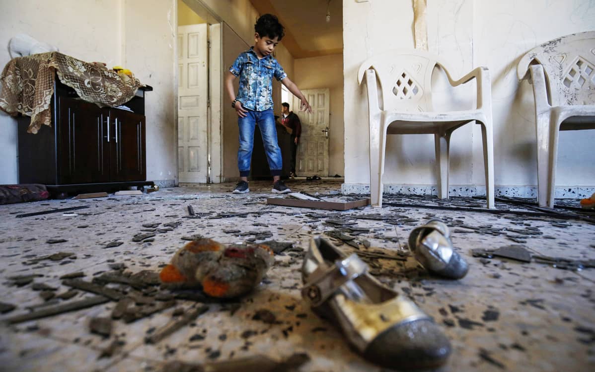 Palestiinalaispoika perheensä vahingoittuneessa asunnossa Israelin ilmaiskun jälkeen Rafahissa sunnuntaina.