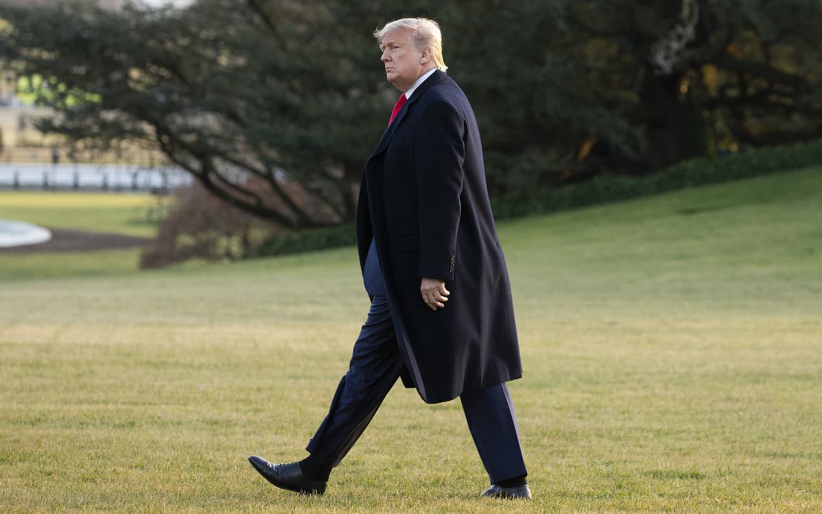 Donald Trump kävelee valkoisen talon nurmella