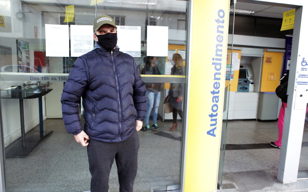 Brasilialainen Andres Sousa odotti Chuíssa pankkivuoroaan. Hengityssuojaimen käyttö on kadulla pakollista. "En ole kuullut, että kukaan olisi oikeasti saanut sakkoja", Sousa sanoo.