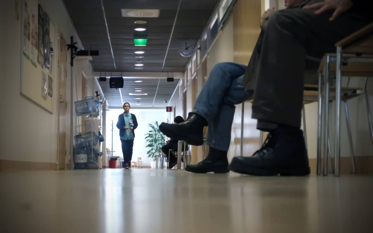 Hoitaja kävelee terveyskeskuksen käytävällä.