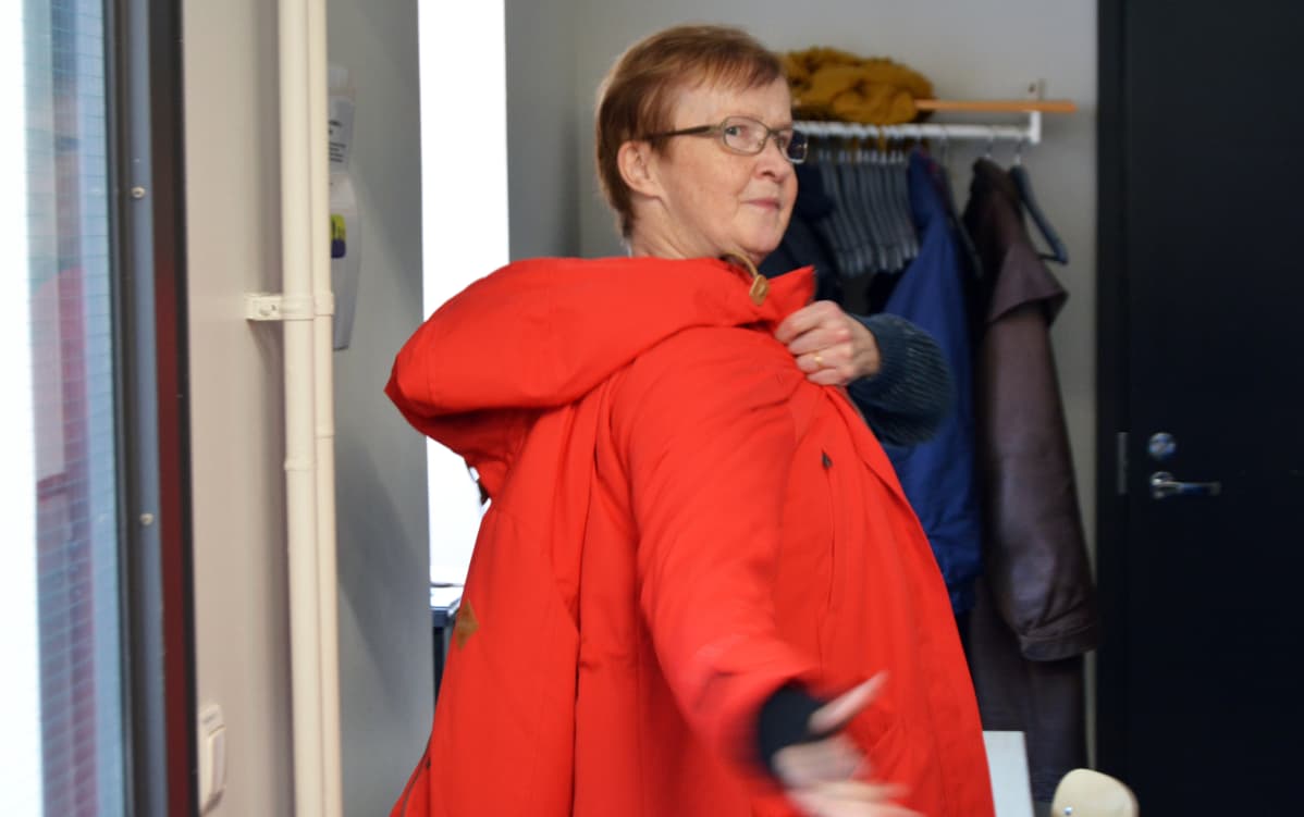 Irene Lindroos laittaa takin ylleen.