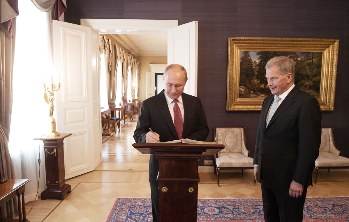 Presidentti Vladimir Putin kirjoittaa Presidentinlinnan vieraskirjaan.