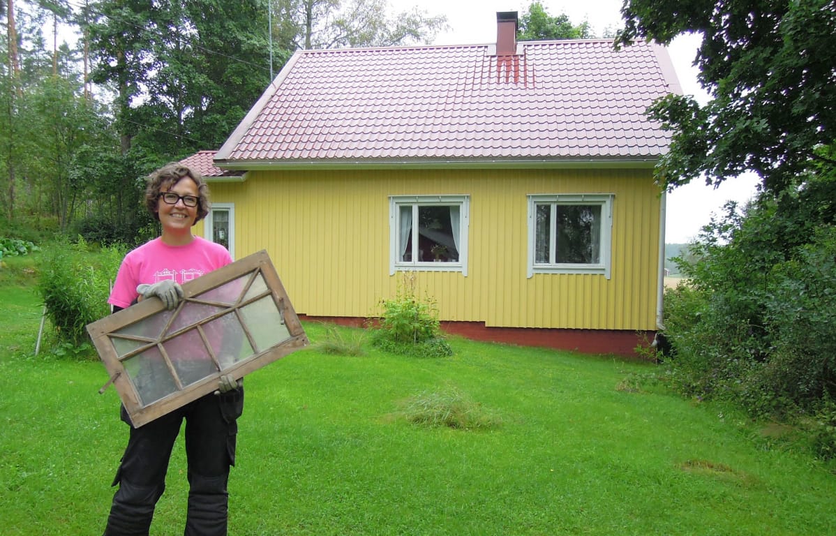 Marika Mattila entisen kesämökkinsä, eli nykyisen kotinsa pihamaalla.