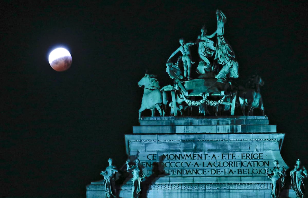 Kuunpimennys Brysselissä maanantaiaamuna 21. tammikuuta. Etualalla monumentaalinen, iso veistos.