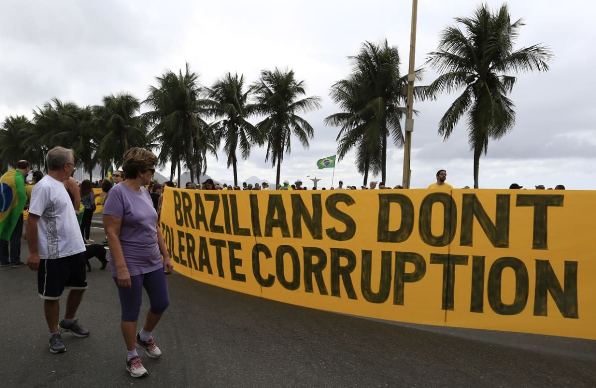 Keltainen lakana jossa lukee "brazilians don't tolerate corruption". Takana palmuja.